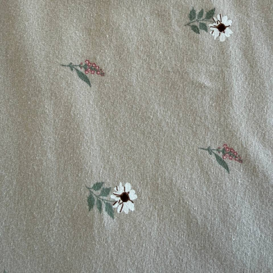 Beige cotton jersey fabric with small scattered floral print