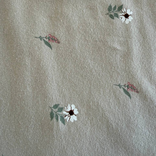 Beige cotton jersey fabric with small scattered floral print