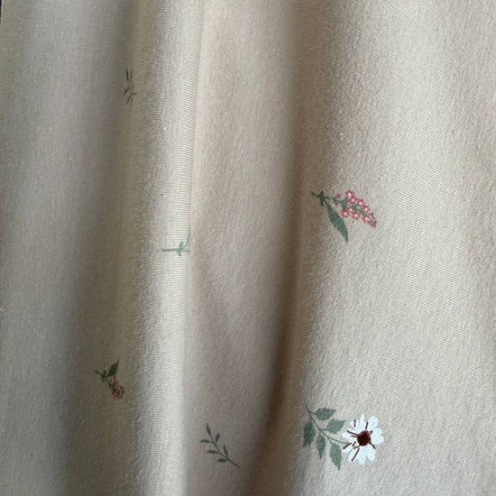 Beige cotton jersey fabric with small scattered floral print