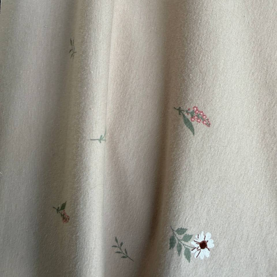 Beige cotton jersey fabric with small scattered floral print