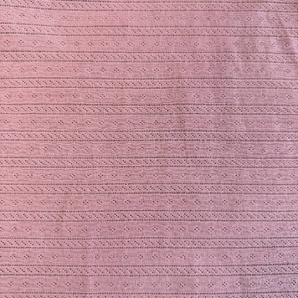 Dusty pink cotton pointelle knit fabric with delicate textured pattern