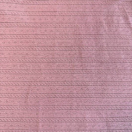 Dusty pink cotton pointelle knit fabric with delicate textured pattern
