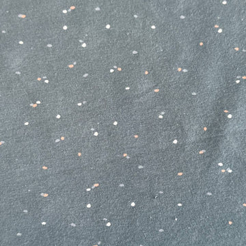 Dusty blue cotton jersey fabric with multicolor speckles, soft stretch knit textile close-up