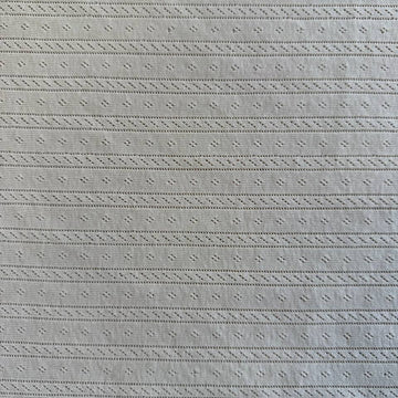 Soft cream cotton pointelle knit fabric with delicate textured pattern
