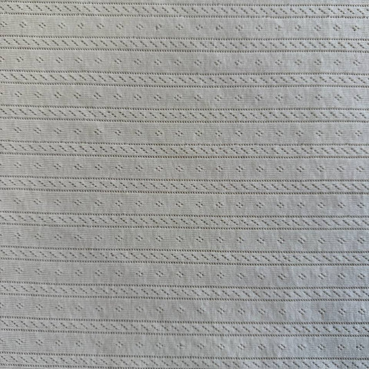 Soft cream cotton pointelle knit fabric with delicate textured pattern