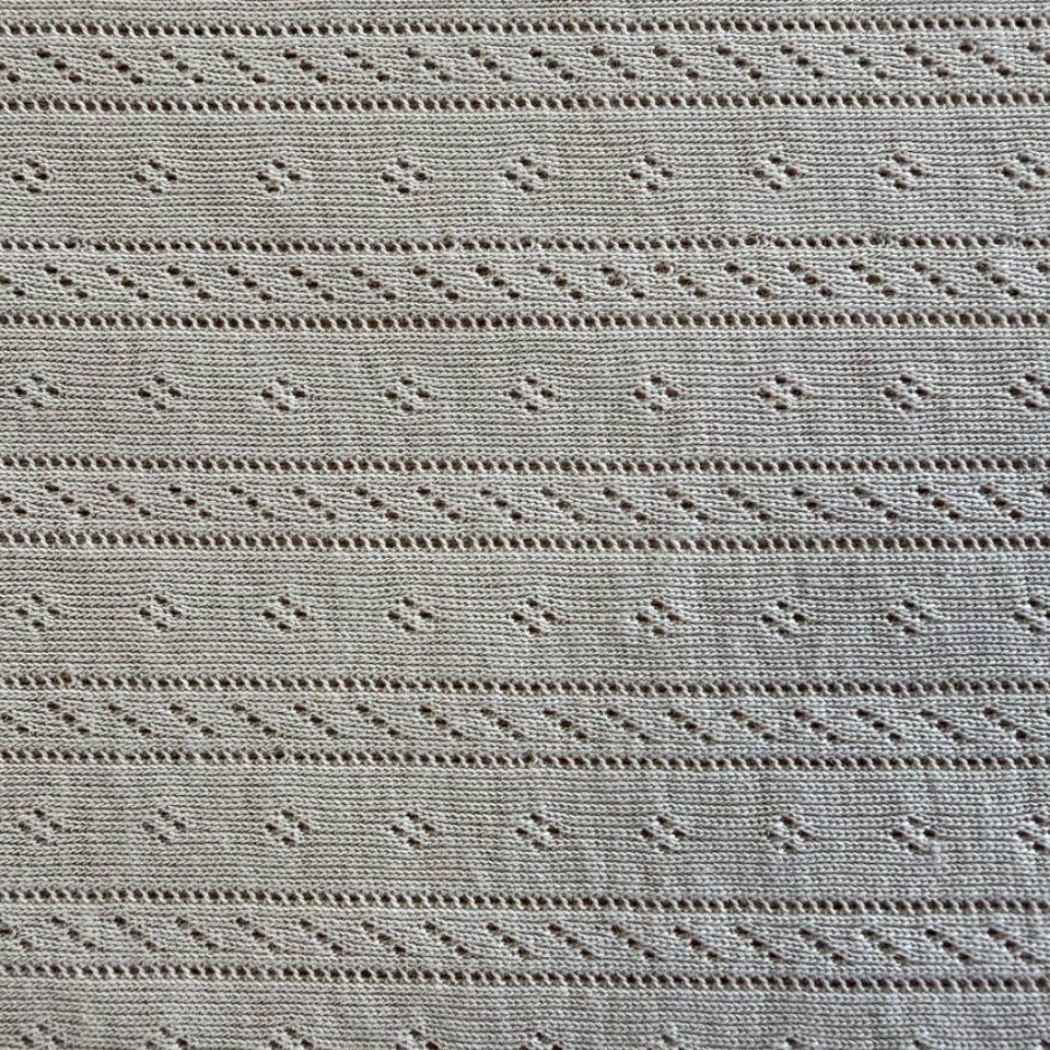 Soft cream cotton pointelle knit fabric with delicate textured pattern