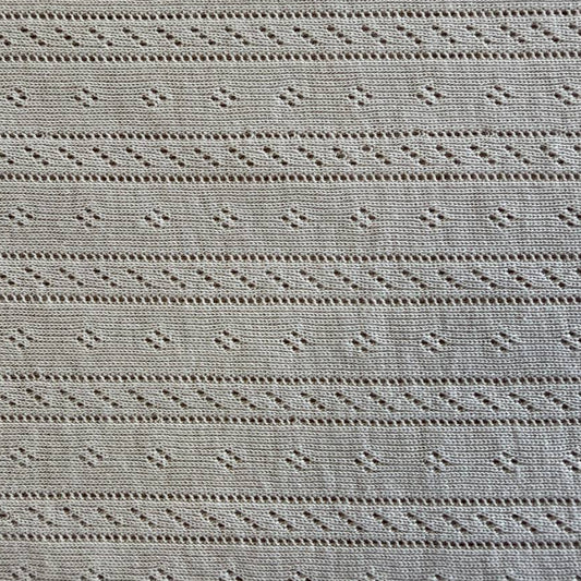 Soft cream cotton pointelle knit fabric with delicate textured pattern