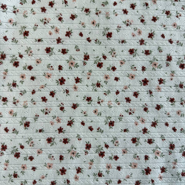White cotton pointelle knit fabric with vintage floral print and delicate texture