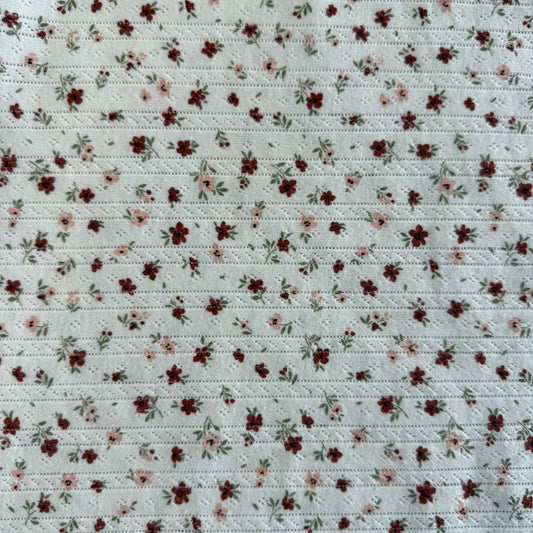 White cotton pointelle knit fabric with vintage floral print and delicate texture