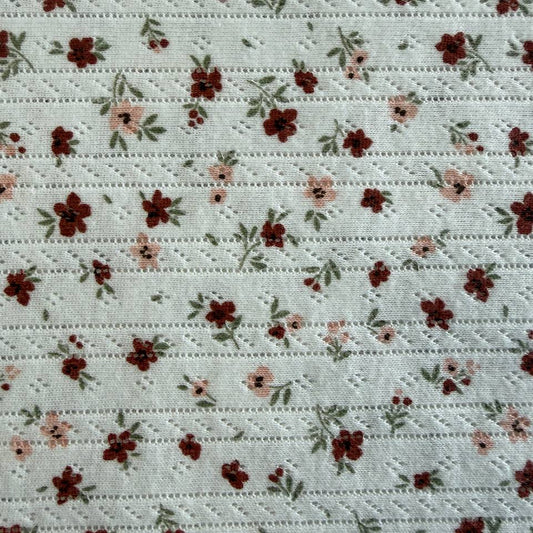 White cotton pointelle knit fabric with vintage floral print and delicate texture