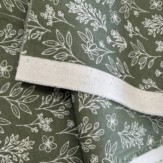 Green cotton fabric with small white botanical floral print, soft quilting cotton texture
