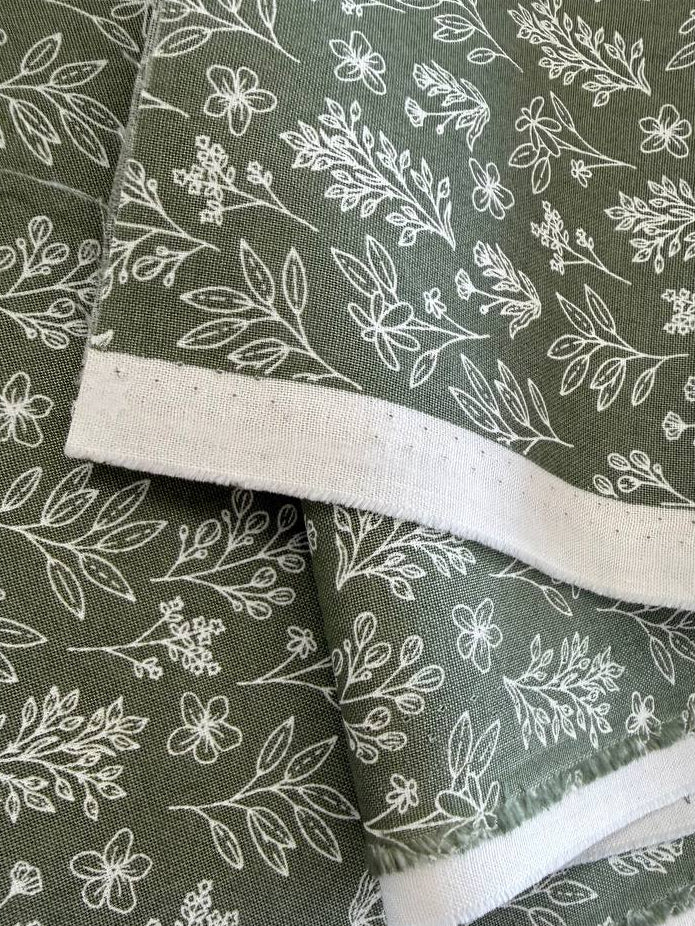 Green cotton fabric with small white botanical floral print, soft quilting cotton texture