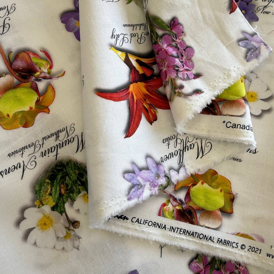 White cotton fabric with colorful botanical flower print and handwritten names from Canadian Road Trip collection by Hoffman