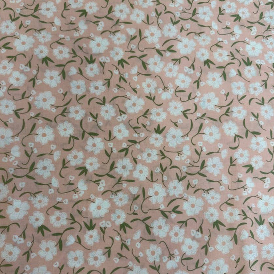 Blush pink cotton fabric with small white flowers and green stems from Flower Girl collection by Sew Quilty Life for Moda