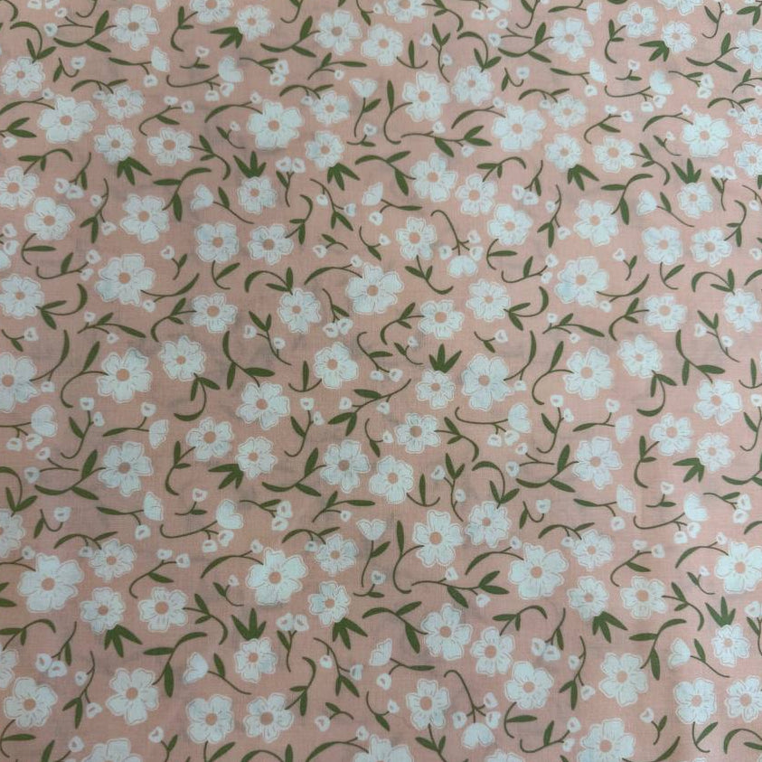 Blush pink cotton fabric with small white flowers and green stems from Flower Girl collection by Sew Quilty Life for Moda