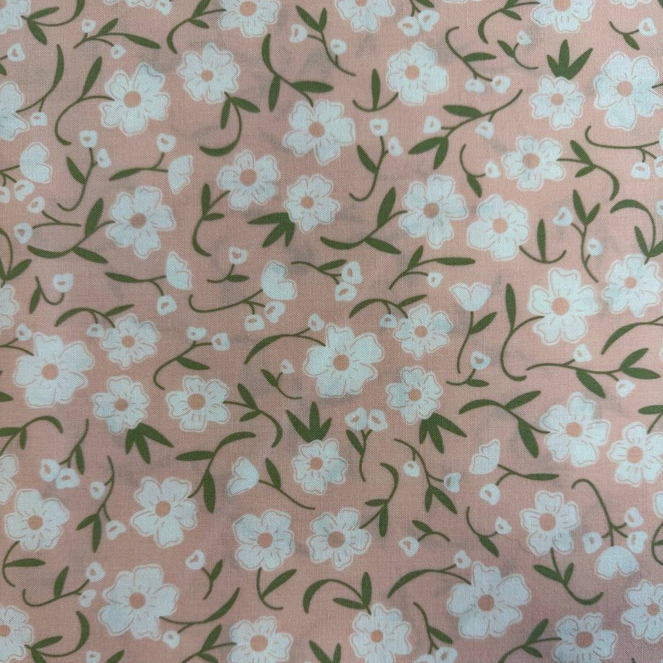 Blush pink cotton fabric with small white flowers and green stems from Flower Girl collection by Sew Quilty Life for Moda