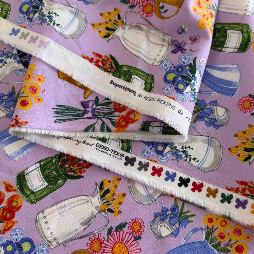 Superbloom Freesia cotton fabric by Robin Pickens for Moda with colorful flowers watering cans and jars on light purple background