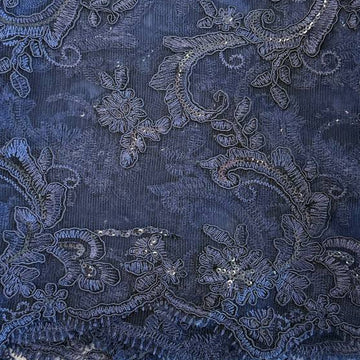 Navy embroidered floral lace fabric with shimmering sequins on a soft mesh base, perfect for formal dresses, bridal wear, and elegant sewing projects.