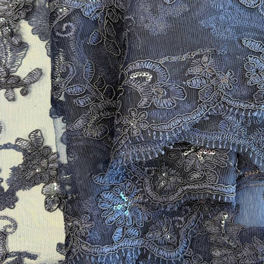 Navy embroidered floral lace fabric with shimmering sequins on a soft mesh base, perfect for formal dresses, bridal wear, and elegant sewing projects.