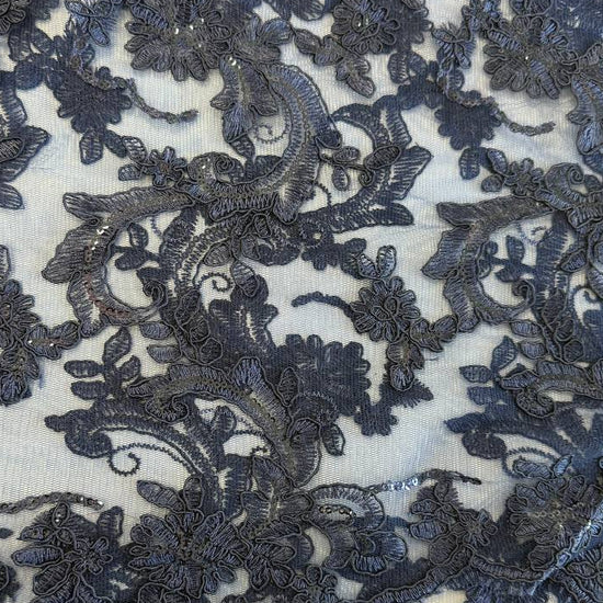 Navy embroidered floral lace fabric with shimmering sequins on a soft mesh base, perfect for formal dresses, bridal wear, and elegant sewing projects.