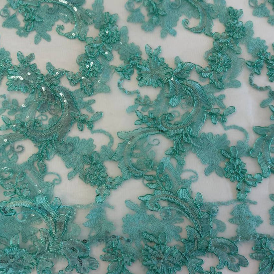 Mint green embroidered floral lace with shimmering sequins on a soft sheer mesh background, featuring elegant scalloped edges, ideal for bridal wear, evening gowns, and formal sewing projects.