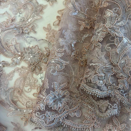 Blush pink embroidered floral lace with delicate sequins on a soft sheer mesh base, featuring an elegant scalloped edge, perfect for bridal gowns, evening dresses, and special occasion sewing projects.