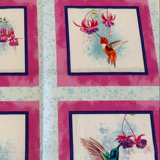 Painted Garden hummingbird cotton fabric panel with pink framed squares and colorful birds with fuchsia flowers on light blue background