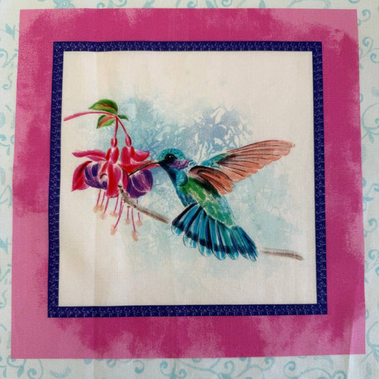 Painted Garden hummingbird cotton fabric panel with pink framed squares and colorful birds with fuchsia flowers on light blue background