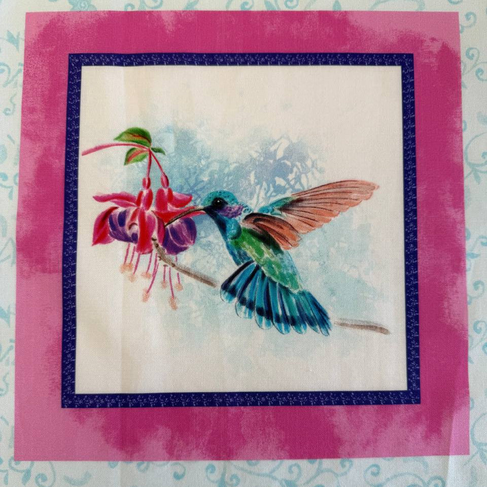 Painted Garden hummingbird cotton fabric panel with pink framed squares and colorful birds with fuchsia flowers on light blue background