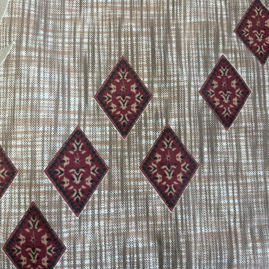 Beige cotton sheeting fabric with burgundy floral motifs, geometric diamonds, and ornamental border design, 108 inch wide bedding fabric displayed at Sasha's Atelier