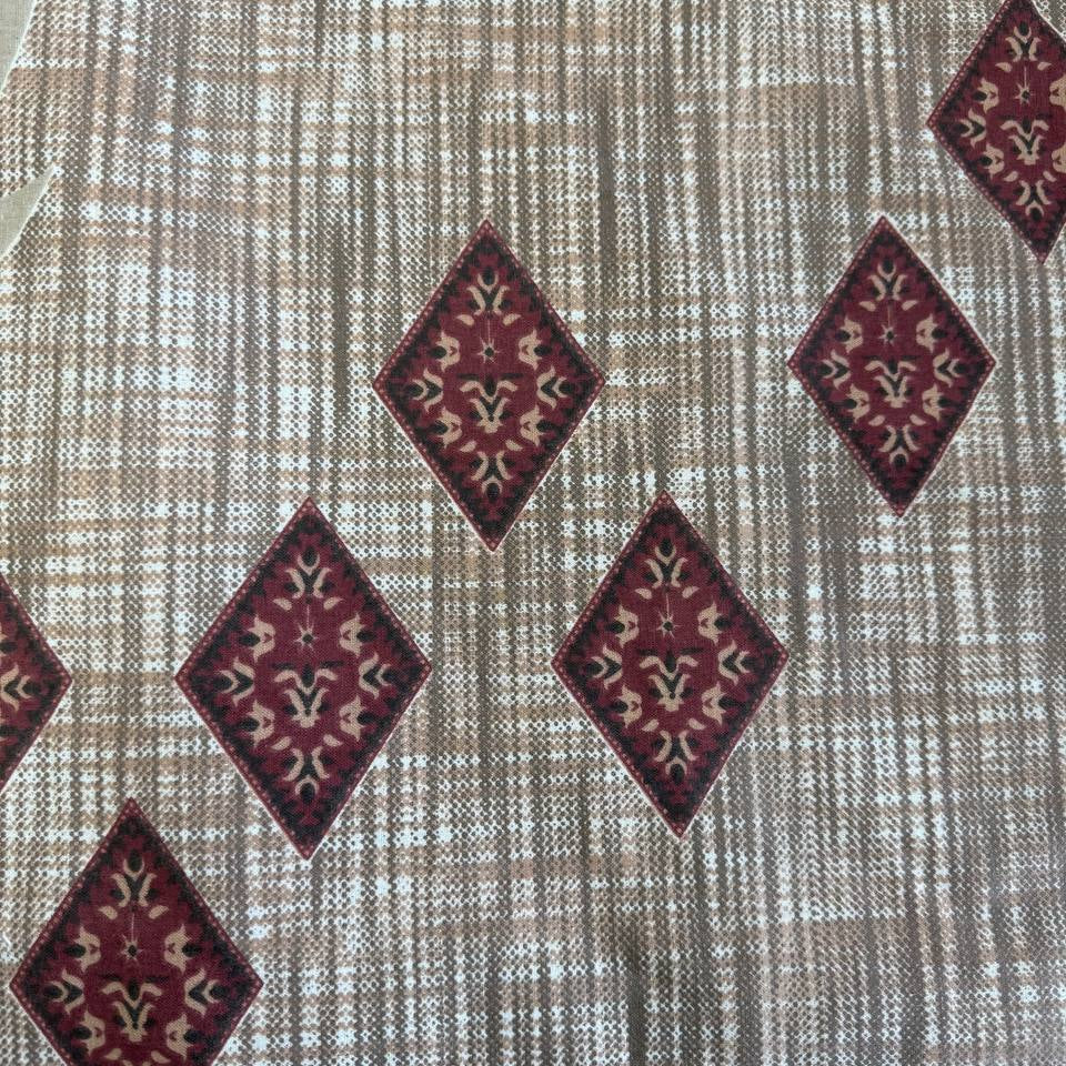 Beige cotton sheeting fabric with burgundy floral motifs, geometric diamonds, and ornamental border design, 108 inch wide bedding fabric displayed at Sasha's Atelier
