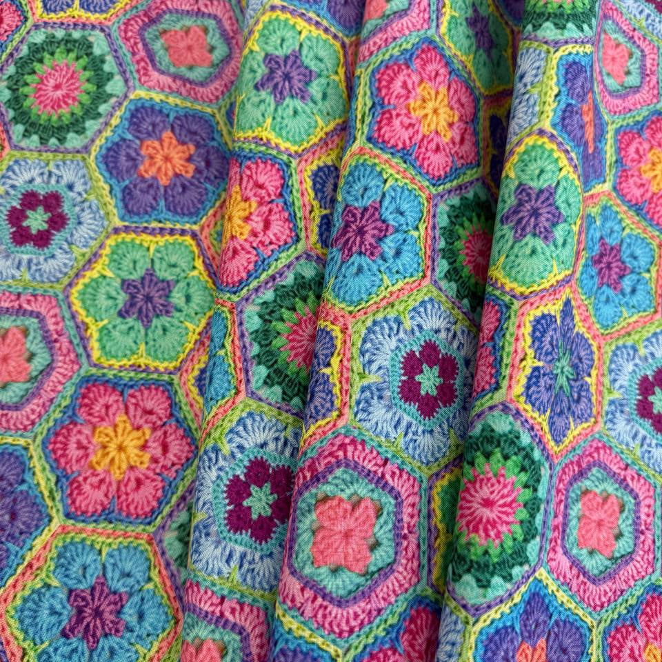 Colourful Northcott Topsy Turtles Crochet Hexie cotton fabric featuring vibrant floral hexagons in pink, purple, turquoise, green, blue and yellow.
