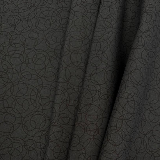 Black cotton quilting fabric by Patrick Lose featuring overlapping geometric circles in a subtle tone-on-tone pattern.