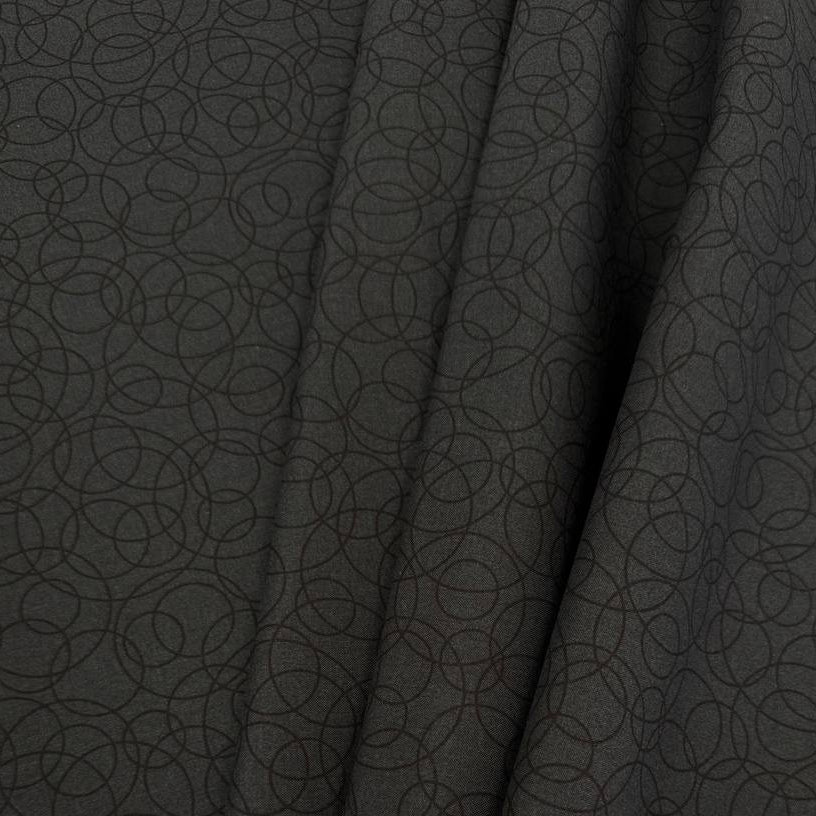 Black cotton quilting fabric by Patrick Lose featuring overlapping geometric circles in a subtle tone-on-tone pattern.