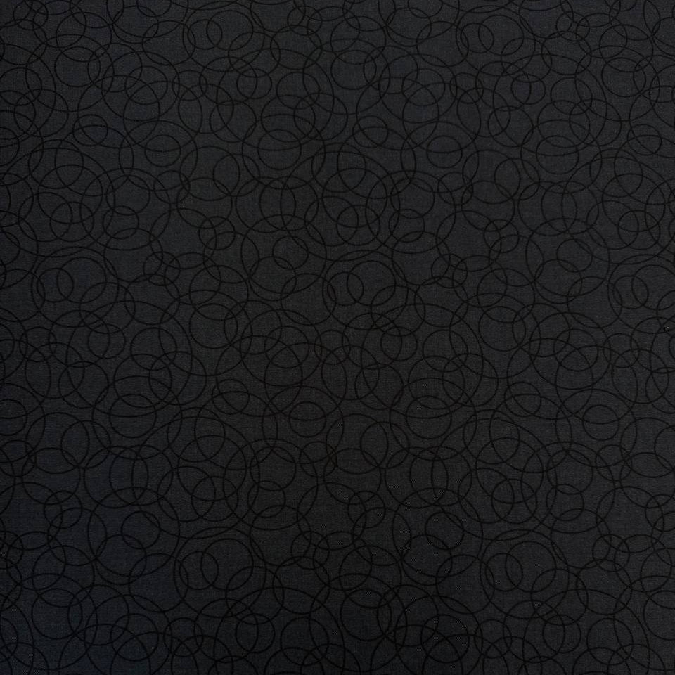 Black cotton quilting fabric by Patrick Lose featuring overlapping geometric circles in a subtle tone-on-tone pattern.