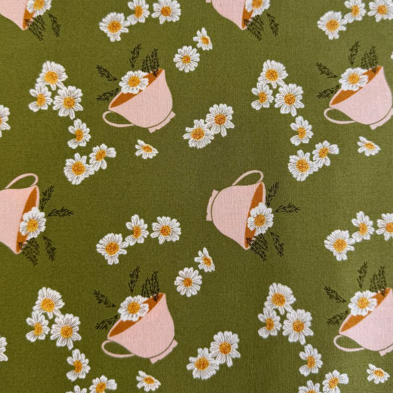 Frivolity cotton fabric with daisies and teacups in green and blush tones