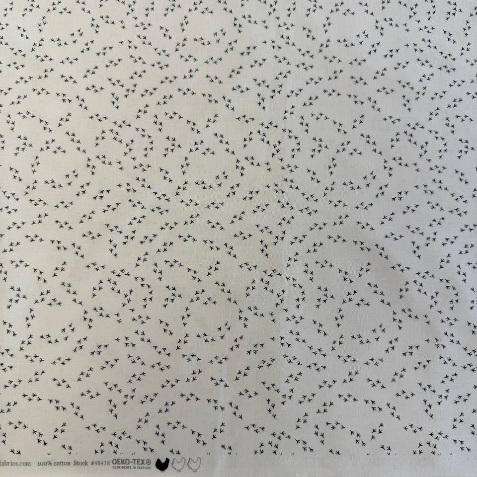 Cream cotton fabric with small black bird footprint pattern from The Henhouse collection by Gingiber for Moda