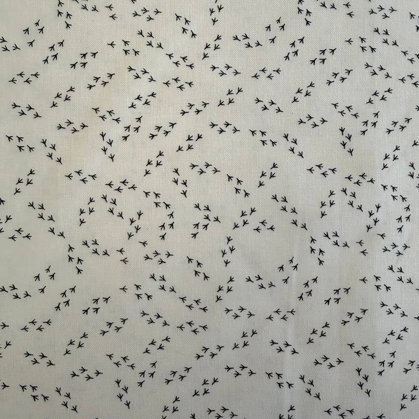 Cream cotton fabric with small black bird footprint pattern from The Henhouse collection by Gingiber for Moda
