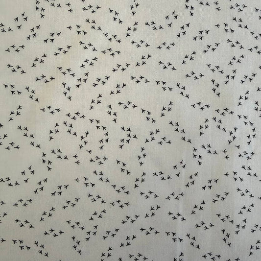 Cream cotton fabric with small black bird footprint pattern from The Henhouse collection by Gingiber for Moda