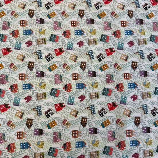 Paper Hamlet fabric by Moda with colorful houses on a light green leafy background