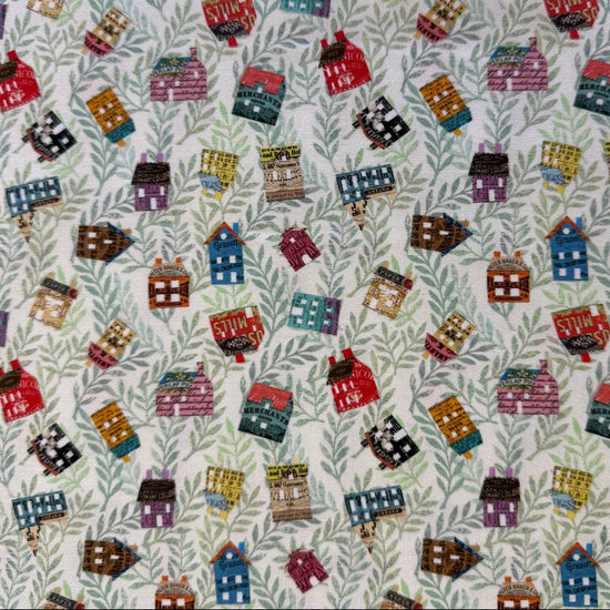 Paper Hamlet fabric by Moda with colorful houses on a light green leafy background
