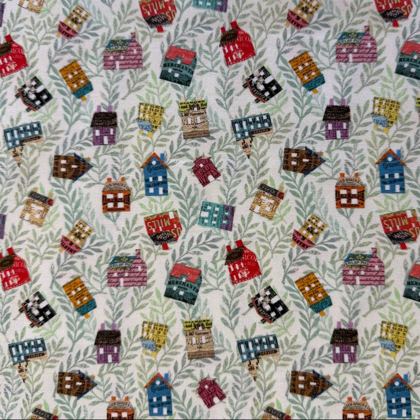 Paper Hamlet fabric by Moda with colorful houses on a light green leafy background