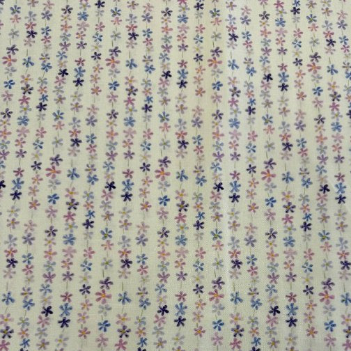 Pastel floral cotton fabric with small purple blue and pink flowers on cream background