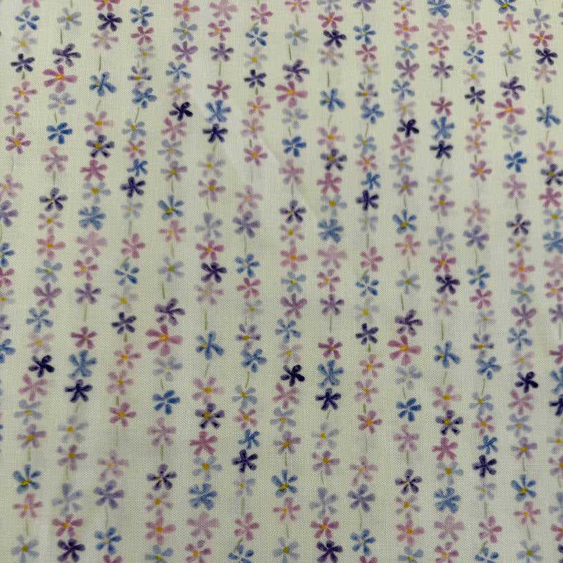 Pastel floral cotton fabric with small purple blue and pink flowers on cream background