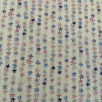 Pastel floral cotton fabric with small purple blue and pink flowers on cream background