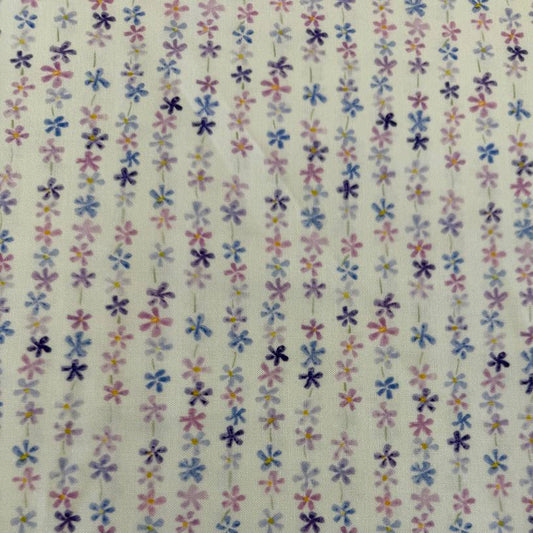 Pastel floral cotton fabric with small purple blue and pink flowers on cream background