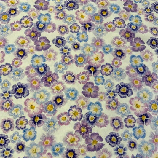 Scattered pastel floral cotton fabric with purple blue and pink flowers on cream background