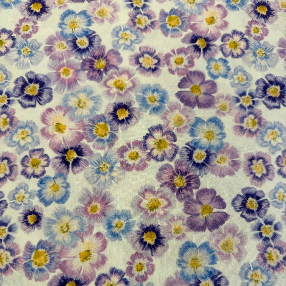 Scattered pastel floral cotton fabric with purple blue and pink flowers on cream background