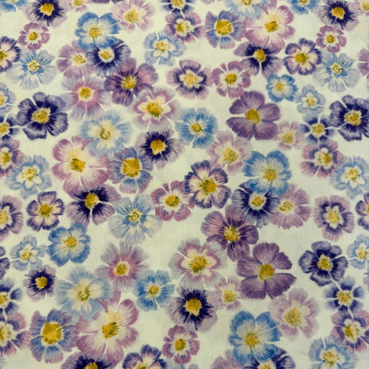 Scattered pastel floral cotton fabric with purple blue and pink flowers on cream background