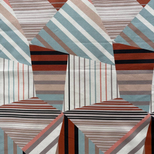 Geometric striped cotton fabric in rust, teal, beige, cream, and black tones with a modern abstract pattern